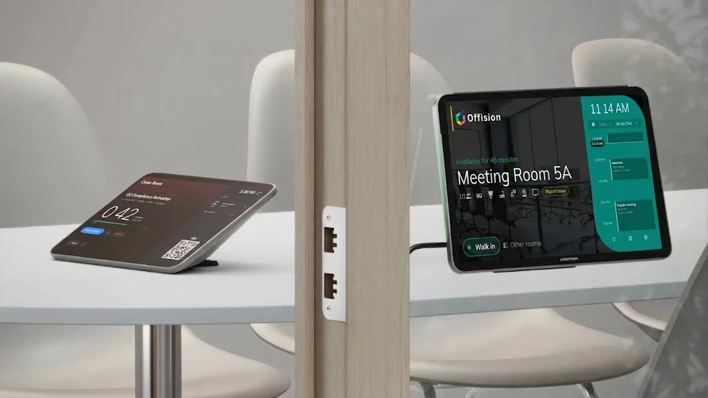 會議桌上的 Offision 簽到平板，旁邊玻璃隔斷上是 Crestron 門口面板顯示 Meeting Room 5A 空閒，中間木柱上有網口