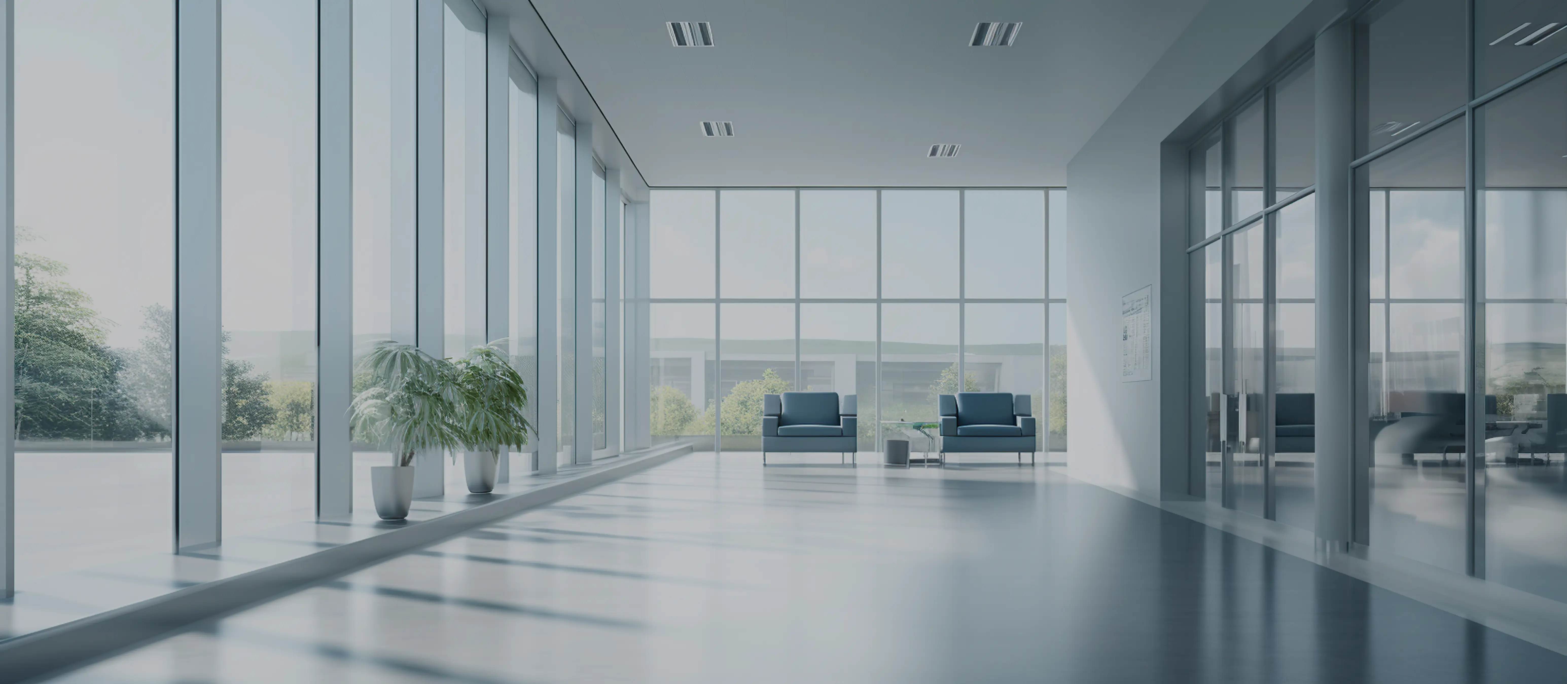 Bright office lobby with floor-to-ceiling glass, a glass-walled meeting room, and a small waiting area.
