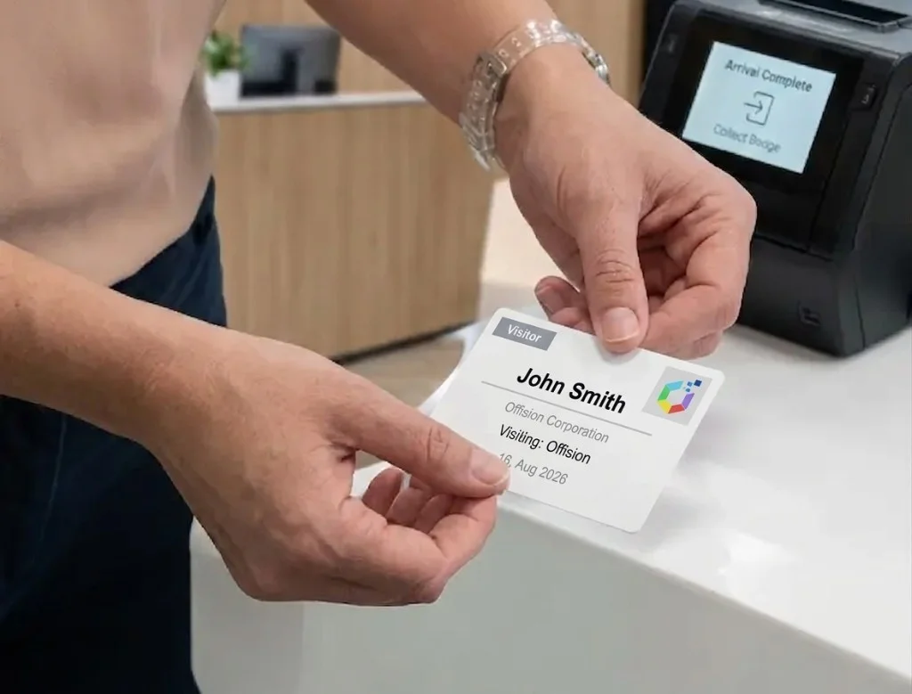 Hands collect a printed Offision visitor badge for John Smith from a lobby printer showing Arrival Complete.